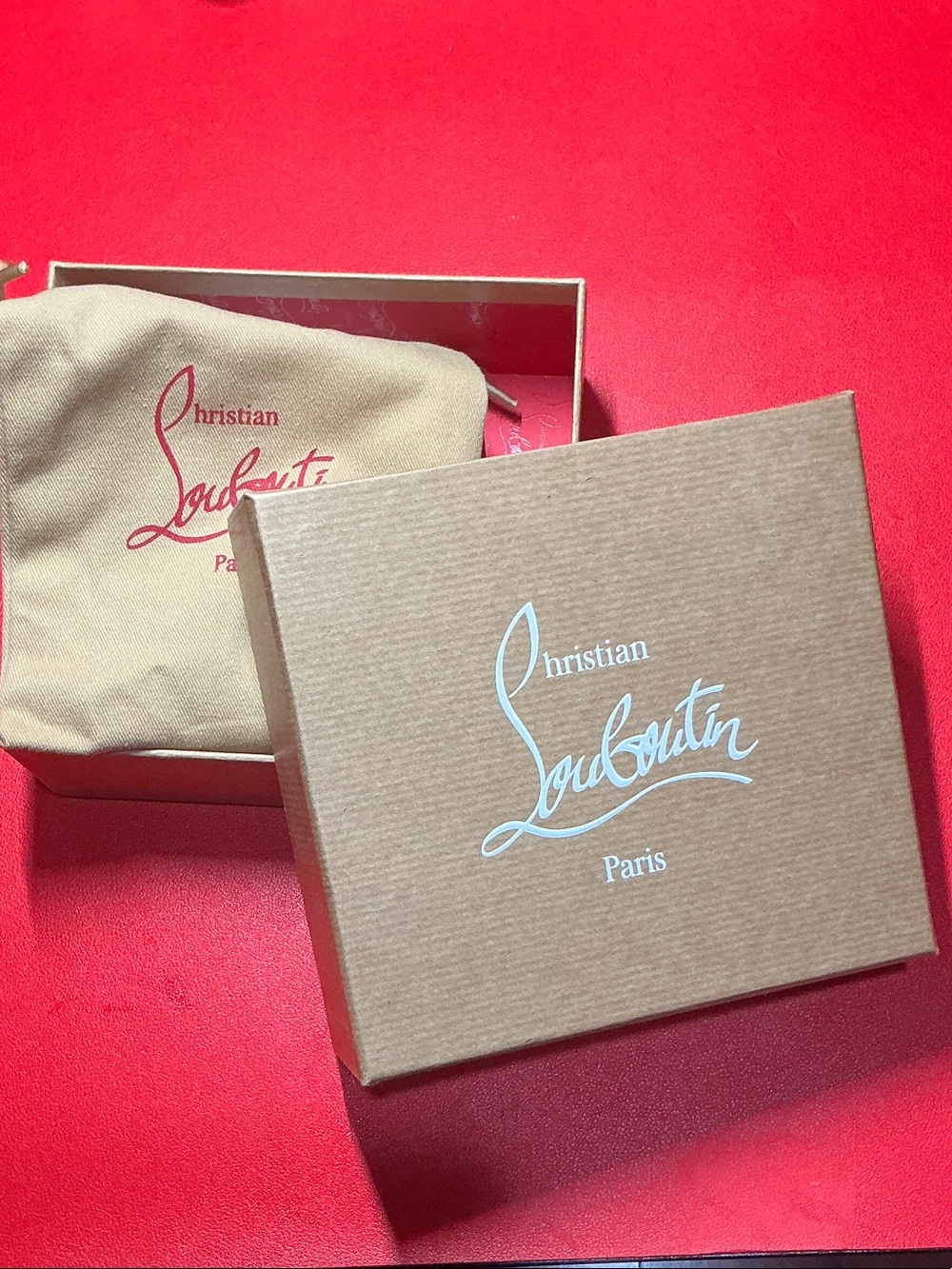 Christian Louboutin Brown Box with Red Logo on Red Background